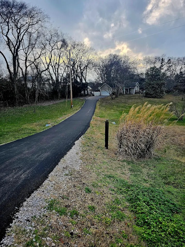 Freshly paved asphalt driveway curving up to a Tennessee home