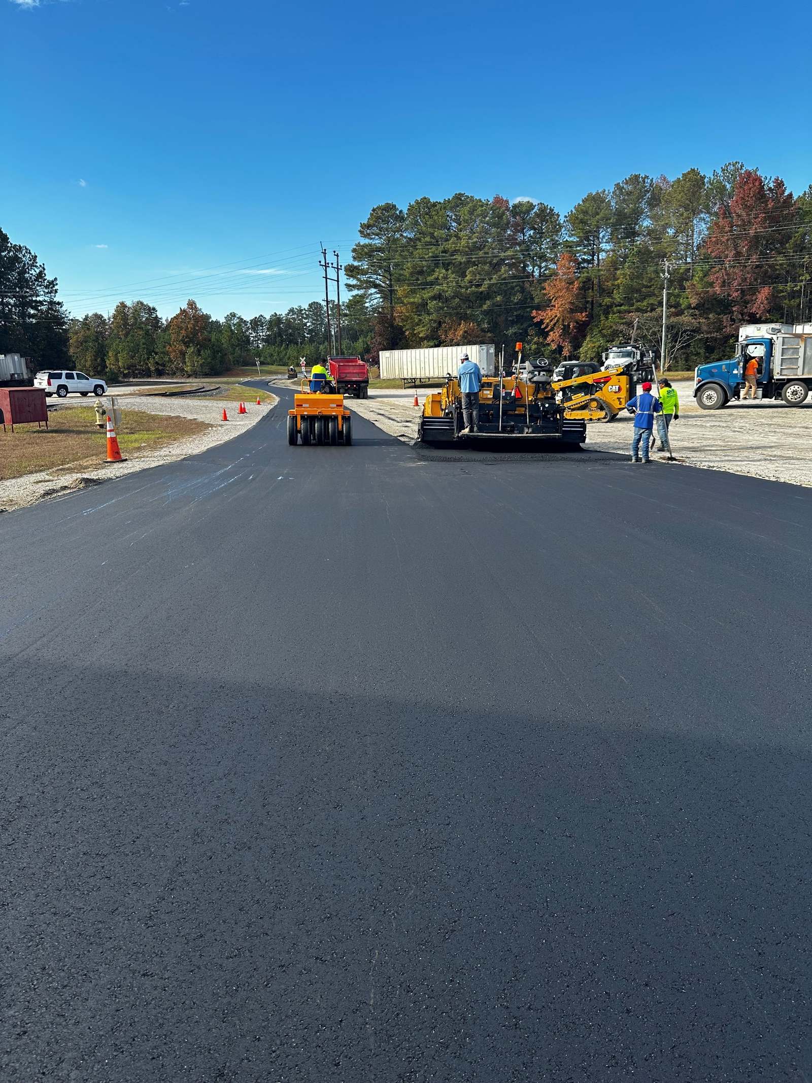 Paver laying fresh asphalt on a commercial parking lot